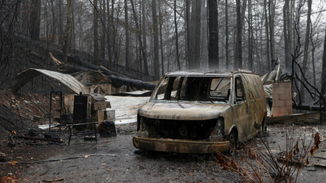 The remains of a van and home smolder in the wake of a wildfire Nov. 30, 2016, in Gatlinburg, Tennessee. 