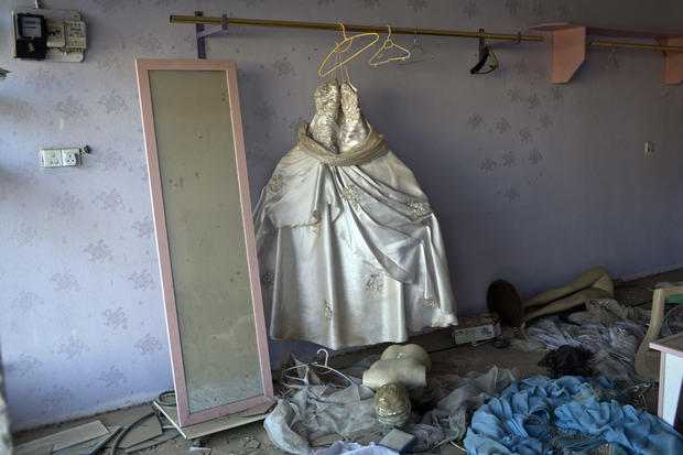 A wedding gown stands in a beauty parlor damaged in clashes between Iraqi security forces and Islamic State of Iraq and Syria fighters in Bartella, Iraq, Oct. 22, 2016. 