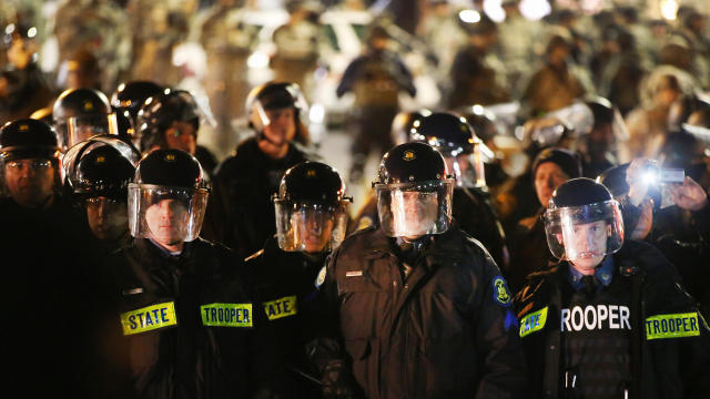 Police and National Guardsmen confront demonstrators outside the police station in Ferguson, Missouri, Nov. 28, 2014. 