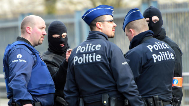 Policemen speak at a security perimeter near Maalbeek-Maelbeek metro station on March 22, 2016, in Brussels after a blast at the station near the EU institutions caused deaths and injuries. 