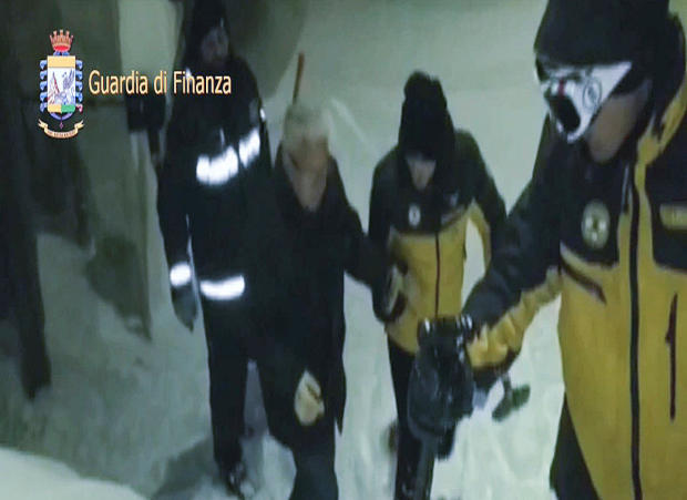 A photo taken from a video provided by Italy’s Finance Police shows a survivor, helped by rescuers, in the same region hit by an avalanche as the Hotel Rigopiano in Farindola, central Italy, Jan. 19, 2017. 