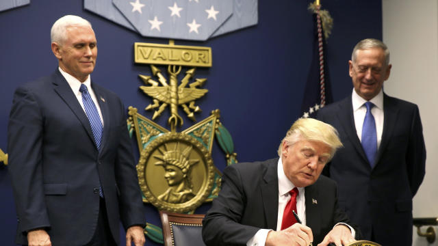 President Trump signs an executive order establishing extreme vetting of people coming to the United States after attending a swearing-in ceremony for Defense Secretary James Mattis, right, with Vice President Mike Pence at the Pentagon Jan. 27, 2017. 