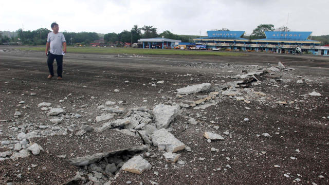 A man walks on the damaged runway at Surigao airport after an earthquake hit Surigao city, southern Philippines, Feb. 11, 2017. 