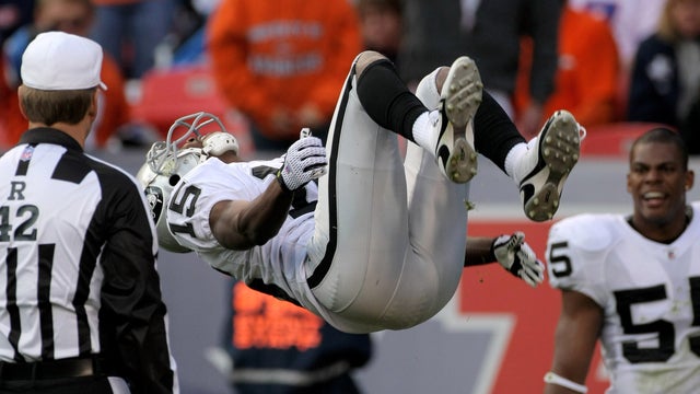 Johnnie Lee Higgins, No. 15 of the Oakland Raiders, celebrates with a backflip in front of referee Jeff Triplette after his 89-yard punt return for a second-quarter touchdown against the Denver Broncos during week 12 NFL action at Invesco Field at Mile Hi 
