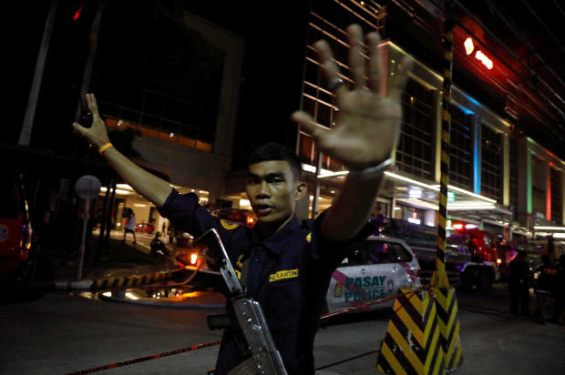 A security guard stops photographers from entering the vicinity of Resorts World Manila after gunshots and explosions were heard in Pasay City, Metro Manila, Philippines, June 2, 2017. 