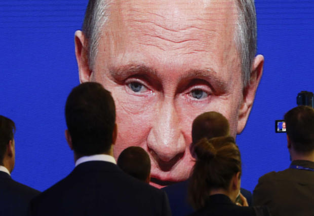 Participants of the St. Petersburg International Economic Forum gather near an electronic screen showing Russian President Vladimir Putin, who is speaking during a session of the forum in St. Petersburg, Russia, June 2, 2017. 