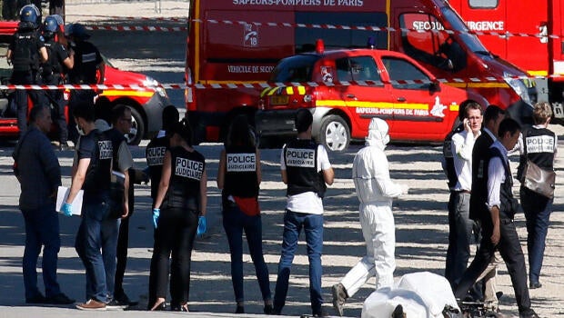 Police inspect the body of a suspect at the scene of an incident in which a car rammed a gendarmerie van on the Champs-Elysees in Paris, France, June 19, 2017.