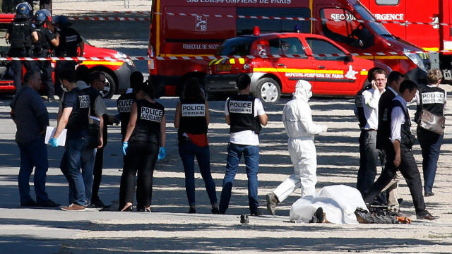 Police inspect the body of a suspect at the scene of an incident in which a car rammed a gendarmerie van on the Champs-Elysees in Paris, France, June 19, 2017. 