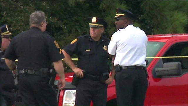 Police work the scene after an officer fatally shot a woman who shot and wounded her husband near a gate at Norfolk Naval Station in Norfolk, Virginia, on July 17, 2017. 