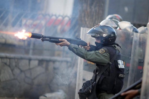 A riot security force member fires his weapon at a rally during a strike called to protest against Venezuelan President Nicolas Maduro's government in Caracas, Venezuela, July 26, 2017. 