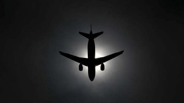 A plane is silhouetted against the sun as it lands at Fiumicino international Airport in Rome, Italy, April 3, 2016. 