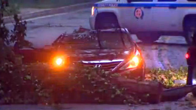 Crews work the scene after a tree fell on a car during a storm in Baltimore County, Maryland, on Aug. 3, 2017. 