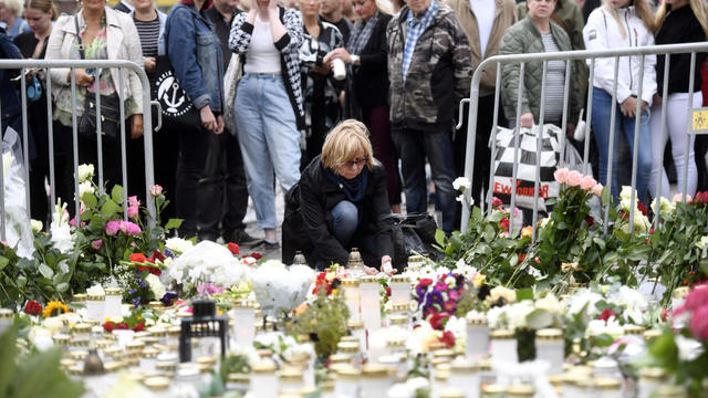 Mourners bring memorial candles and flowers to the Turku Market Square 