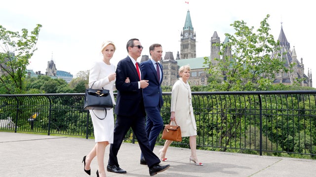 FILE PHOTO: U.S. Secretary of the Treasury Mnuchin, his fiancee Louise Linton, Canada's Finance Minister Morneau and his wife McCain walk past Parliament Hill  in Ottawa 
