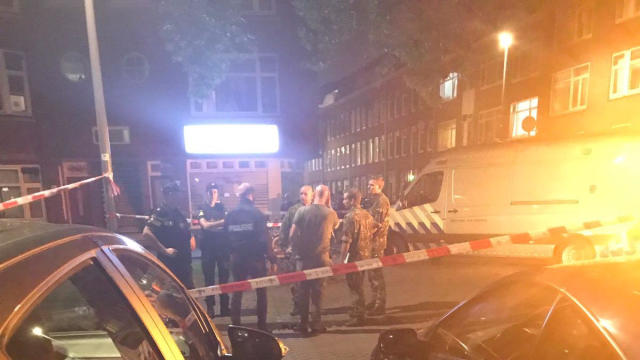 People gather at the scene where police are investigating a van with Spanish licence plates containing gas bottles which was found near a concert hall in Rotterdam 