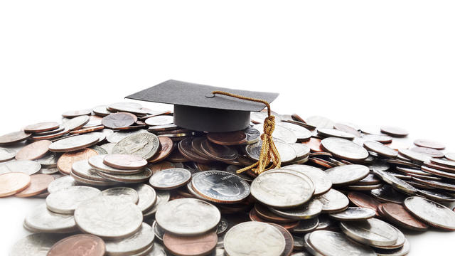 Graduation cap on money pile 