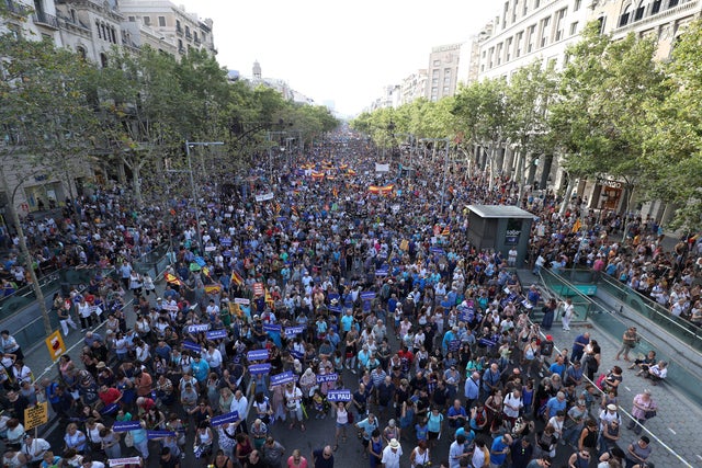 People hold signs and flags as they take part in a march of unity after the attacks last week, in Barcelona, Spain 