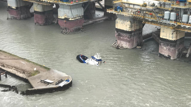 People stand on a sinking boat awaiting rescue from a U.S. Coast Guard helicopter, after Hurricane Harvey passed near Port Aransas 