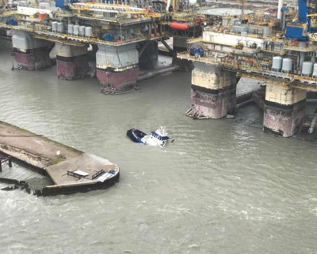 People stand on a sinking boat awaiting rescue from a U.S. Coast Guard helicopter, after Hurricane Harvey passed near Port Aransas 