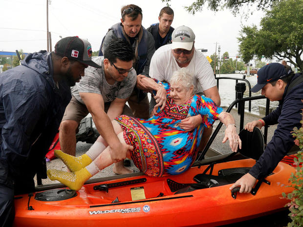 Sterling Broughton is moved from a rescue boat onto a kayak in Dickenson, Texas 