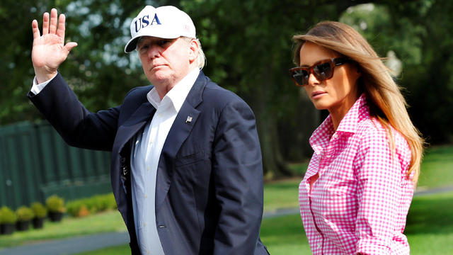 President Donald Trump waves as he walks with first lady Melania Trump on South Lawn of the White House in Washington 