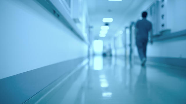 Blurred medical background. Moving human figure in the hospital corridor. 