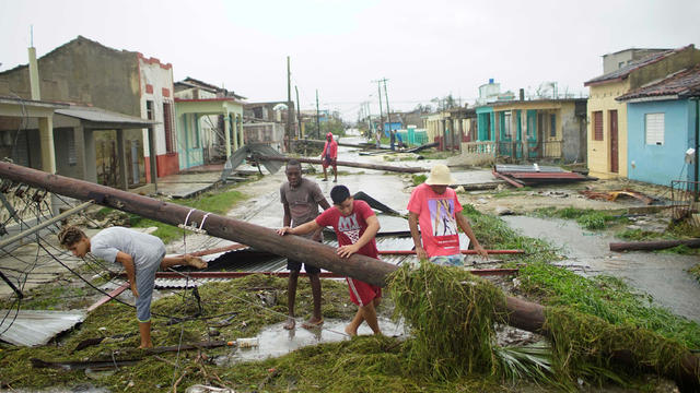 People walk on a damaged street after the passage of Hurricane Irma in Caibarien, Cuba 