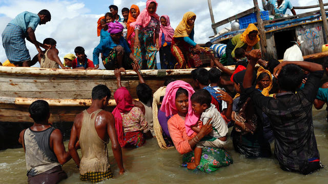 Rohingya refugees get off a boat after crossing the Bangladesh-Myanmar border through the Bay of Bengal, in Shah Porir Dwip 