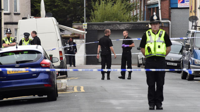 Officers stand behind police cordon after three men were arrested in connection with an explosion on the London Underground, in Newport, Wales 