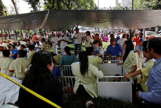 Nurses stand around cribs with small children after they were evacuated after an earthquake hit Mexico City 