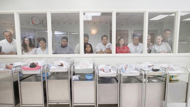 New parents watching babies in hospital nursery