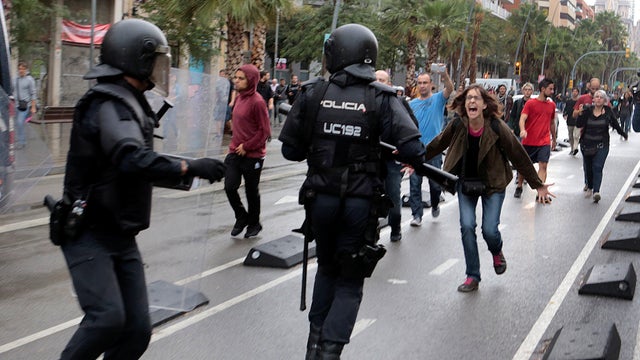 A woman yells at riot police near a polling station for the banned independence referendum in Barcelona 