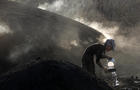 A woman sprays water on burning woods during a charcoal making process near Kizilcahamam 