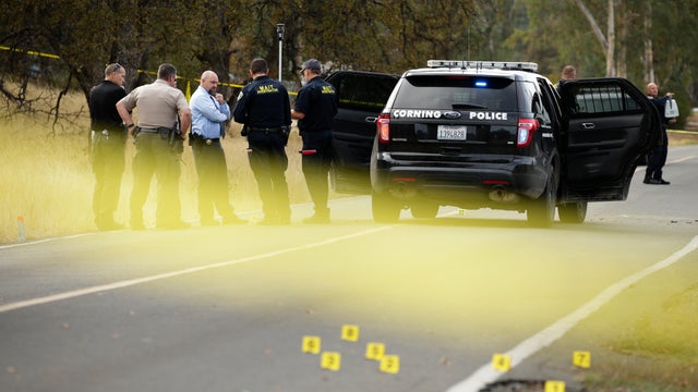 Law enforcement officers and investigators converse near a police vehicle that was involved in a shooting on Nov. 14, 2017, in Rancho Tehama, California. 
