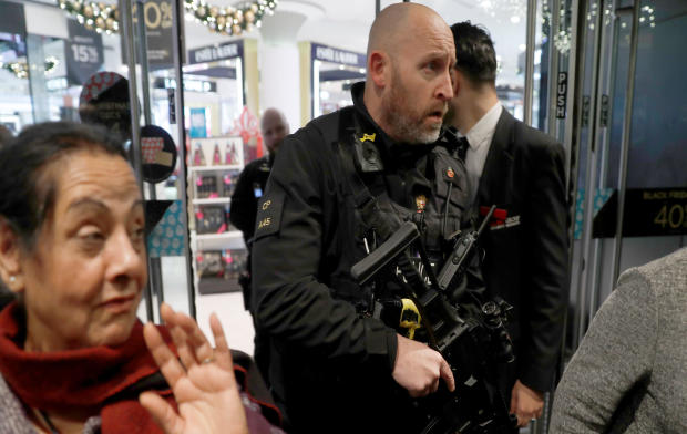 Armed police officers mix with shoppers in an Oxford Street store in London, Britain, Nov. 24, 2017. 