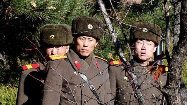 North Korean soldiers look at the South near where a North Korean defected as South Korean Defense Minister Song Young-moo visits the area on Nov. 27, 2017, in Panmunjom. 