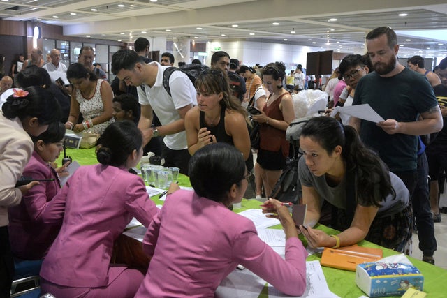 Passengers ask staff about their flights after Ngurah Rai airport closed their operation due to eruption of Mount Agung in Bali resort island 