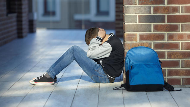 schoolboy crying in the hallway of the school 