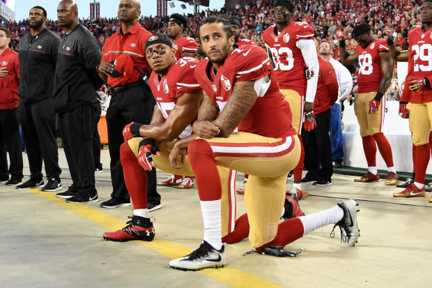 Colin Kaepernick, center, and Eric Reid of the San Francisco 49ers kneel in protest during the national anthem prior to playing the Los Angeles Rams in their NFL game at Levi's Stadium on Sept. 12, 2016, in Santa Clara, California. 
