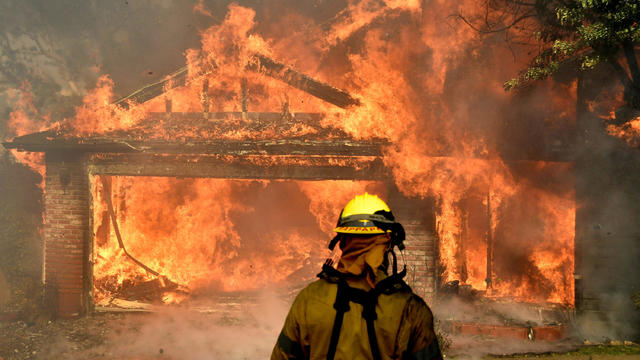 Firefighters battle to save one of many homes burning in the so-called Creek Fire that broke out in the Kagel Canyon area in the San Fernando Valley north of Los Angeles, in Sylmar, California, Dec. 5, 2017. 