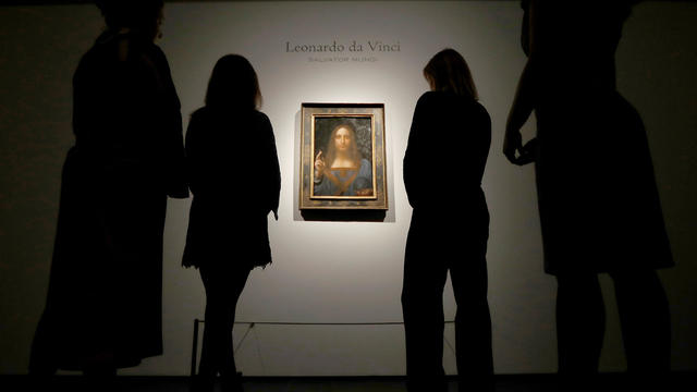 FILE PHOTO: Members of Christie's staff pose for pictures next to Leonardo da Vinci's "Salvator Mundi" painting in London 