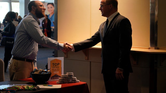 Job seeker Steven Walsh talks to Clinica Family Health lead recruiter David Jaquith at the Colorado Hospital Association job fair in Denver 