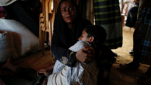 Shajeda Khan cries as she holds her unconscious son Salamat, 14, whose family says he was attacked by relatives of the girl he was arranged to marry but refused, at the Mayner Ghona refugee camp near Cox's Baza 