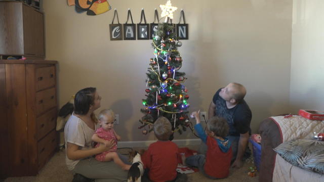 amanda-richard-and-children-michael-daniel-and-heaven-with-their-tree-donated-by-the-christmas-tree-project-credit-cbs-news.jpg 