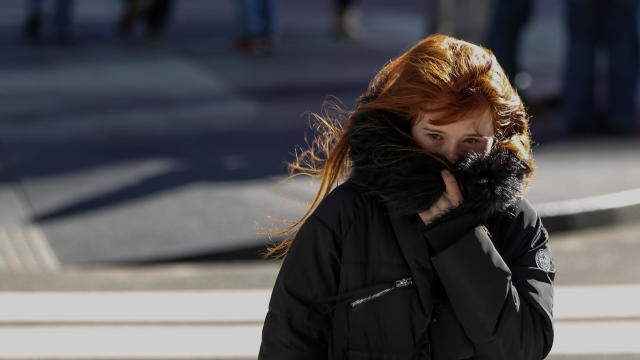 A woman bundles up against the cold temperature as she walks in Times Square in New York 