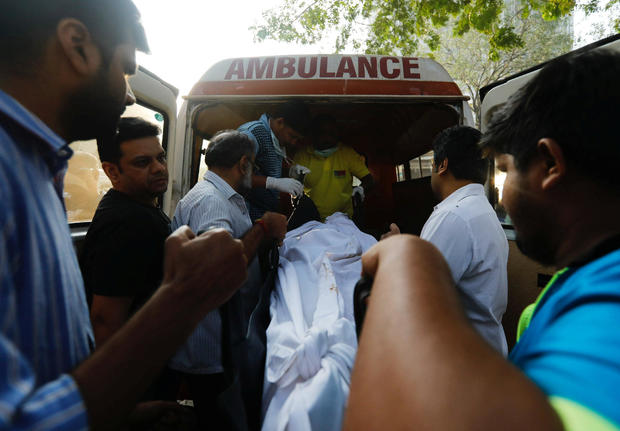 Family members carry the body of victim killed in a fire at a restaurant from a hospital in Mumbai 