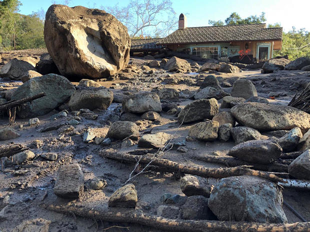 A damaged house is surrounded by large boulders and debris following mudslides due to heavy rains in Montecito 