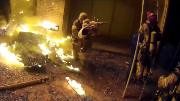 DeKalb County Fire Rescue Capt. Scott Stroup catches a young child dropped from an apartment fire in Decatur, Georgia, on Jan. 3, 2018.