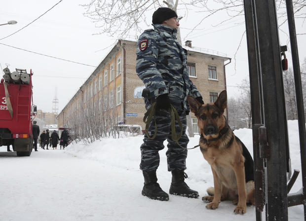 A policeman with a dog stands guard near a local school after reportedly several unidentified people wearing masks injured schoolchildren with knives in Perm 