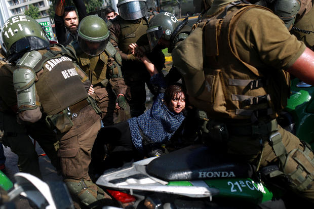 A woman is detained during a protest against Papal visit in Santiago 